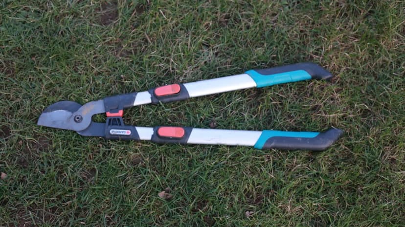 Coupe-branches Gardena TeleCut Pro L posé ouvert sur pelouse, vue de dessus